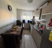 Küche in einer 3-Zimmer-Wohnung mit Esstisch, Holzboden und Fenster.