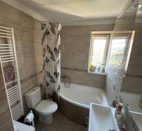 Badezimmer in einer 3-Zimmer-Wohnung mit Badewanne, Waschbecken und Fenster für natürliches Licht.