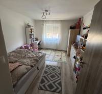 Kinderzimmer mit Bett und Fenster in einer 3-Zimmer-Wohnung, heller Holzboden.
