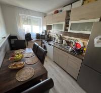Küche in einer 3-Zimmer-Wohnung mit Tisch, Stühlen und moderner Ausstattung in angenehmem Licht.