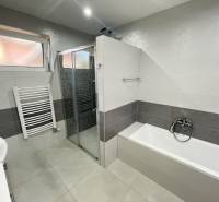 Badezimmer mit Badewanne und Dusche in einem Einfamilienhaus.