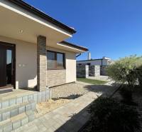 Ein Einfamilienhaus in Prešov mit Terrasse, gepflegtem Garten und gepflastertem Gehweg.