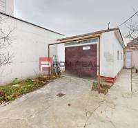 Hof bei einem Einfamilienhaus in der Farebná-Straße in Bratislava II mit Garage und Bäumen.