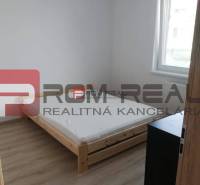 Einfaches Schlafzimmer mit Licht, Bett und Möbeln in einer 2-Zimmer-Wohnung in der Slavomírova-Straße.
