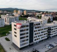 Geschäftsräume in der Obchodná-Straße in Pezinok, umgeben von Wohnhäusern und Grünflächen.