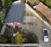 Luftaufnahme eines Familienhausgartens in Pezinok mit geparktem Auto und Garage.