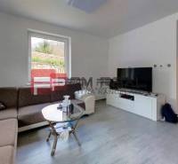 Wohnzimmer mit Ecksofa, Couchtisch und Fernseher in einem Einfamilienhaus.