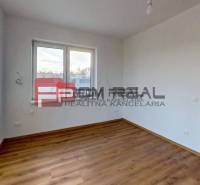 Ein Zimmer in einem Einfamilienhaus mit Holzboden und Blick aus dem Fenster.