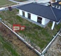 Ein Einfamilienhaus in Častá mit einem schrägen Dach, umgeben von einem Zaun, mit einem grasbewachsenen Grundstück.