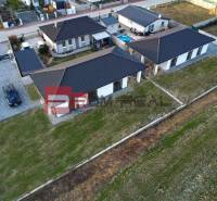 Ein Einfamilienhaus in Častá mit mehreren Gebäuden, Garten, gepflastertem Parkplatz, Umzäunung.