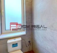 Badezimmer in einem Einfamilienhaus mit Fenster und Toilette.