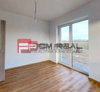 Ein Zimmer im Einfamilienhaus mit Laminatboden und Terrassentüren.
