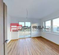 Ein Zimmer in einem Einfamilienhaus mit Holzboden und großen Fenstern.