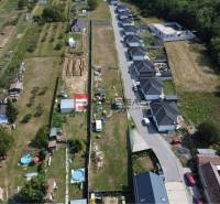 Luftaufnahme von Wohnbaugrundstücken in Štefanová, angrenzend an eine Reihenhaussiedlung.