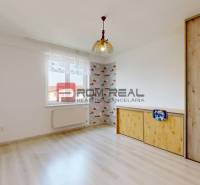 Ein Zimmer in einer 4-Zimmer-Wohnung mit einem Holzschrank und Tapeten an der Wand.