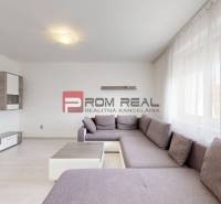 Wohnzimmer in einer 4-Zimmer-Wohnung mit geräumigem Sofa und Fernseher.