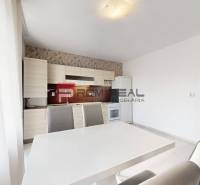 Helle Küche in einer 4-Zimmer-Wohnung mit Esstisch und grauen Stühlen.