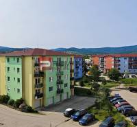 Bunte Wohnhäuser in der Muškátová-Straße in Pezinok mit Autos in der Parkzone.