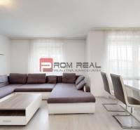 Wohnzimmer mit Ecksofa in einer 4-Zimmer-Wohnung, ergänzt durch Tisch und Stühle.