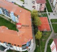 Luftaufnahme von Wohnblöcken in der Muškátová-Straße in Pezinok mit einem Sportplatz.