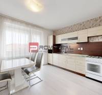 Küche in einer 4-Zimmer-Wohnung mit Esstisch, Stühlen und Küchenzeile.