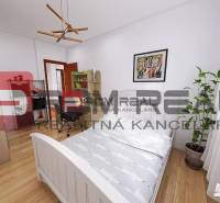 Helles Schlafzimmer in einer 3-Zimmer-Wohnung mit Bett, Schreibtisch und großem Fenster.