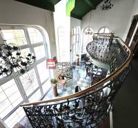 Das Innere zeigt eine elegante Treppe und einen Balkon in der Ľ. Podjavorinská-Straße, übergroße Fenster betonen das historische Gebäude.