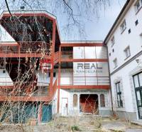 Das Gebäude in der Ľ. Podjavorinská-Straße in Trnava mit einer Außentreppe aus Metall und verglasten Fenstern.