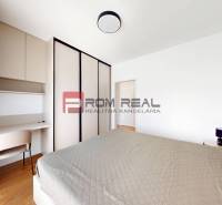 Schlafzimmer in einer 2-Zimmer-Wohnung mit Bett, Kleiderschrank und Schreibtisch.