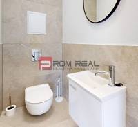 Badezimmer in einer 2-Zimmer-Wohnung mit Toilette, Waschbecken und Spiegel.