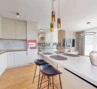 Küche und Wohnzimmer mit Insel und Stühlen in einer 2-Zimmer-Wohnung.