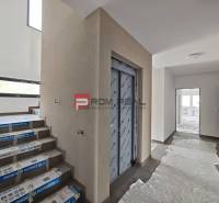 Flur mit Aufzug, Treppenhaus und Kunststoffabdeckung in einer 2-Zimmer-Wohnung.