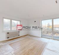 Ein Zimmer mit Holzboden und großen Fenstern bietet Helligkeit in einer 2-Zimmer-Wohnung.