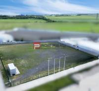 Produktionsräume in Pezinok mit eingezäuntem Außenbereich und Container, umgeben von Feldern.