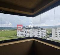 Blick vom Balkon einer 4-Zimmer-Wohnung auf grüne Felder und umliegende Gebäude in Pezinok.