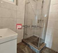 Badezimmer in einer 4-Zimmer-Wohnung mit Duschkabine und Waschbecken.