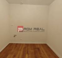 Ein Zimmer mit weißen Wänden und Holzboden in einer 4-Zimmer-Wohnung.