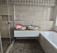 Ein Badezimmer in einer 4-Zimmer-Wohnung mit einer Dusche, einer Badewanne und einem Doppelwaschbecken.