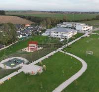 Spielplatz und Grünflächen in der Umgebung von Einfamilienhäusern in Slovenský Grob.