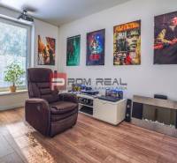 Spielzimmer mit einem bequemen Sessel, Wanddekorationen, einer Gitarre und einem Audiosystem in einem Einfamilienhaus.
