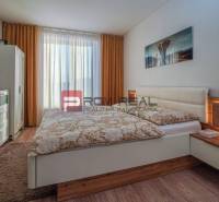 Schlafzimmer in einem Einfamilienhaus mit Bett, Schrank und Fernseher an der Wand.