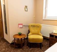 Hotelzimmer mit Sessel, Tisch, Lampe und Telefon, geeignet für Entspannung.