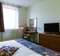 Izba s posteľou, stolíkom a televíziou v Hotely a penzióny.

Zimmer mit Bett, Tisch und Fernseher in Hotels und Pensionen.
