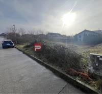 Baugrundstück in Stupava in der Bazova-Straße, sonnige Umgebung und Auto an der Straße.