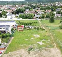 Grundstücke zum Wohnen in Marianka in der Straße Na Ovsisku, umgeben von grünen Gärten und Häusern.