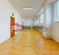 Ein geräumiger, heller Raum mit Holzboden, Heizkörpern und Fenstern in Lagerhäusern und Hallen.