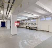 Innenräume von Lagern und Hallen mit hellen Wänden, Rohrleitungen und eingebauten Tischen.