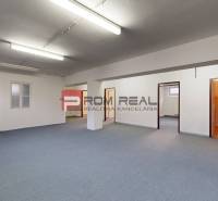 Ein geräumiger Büroraum mit mehreren Türen und blauem Teppich in Lagerhallen.