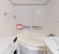 Badezimmer mit Dusche, Waschmaschine und Waschbecken in einer 4-Zimmer-Wohnung.