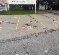 Parkplätze mit Blockierern auf der Púchovská-Straße, Bratislava III vor den Garagen.